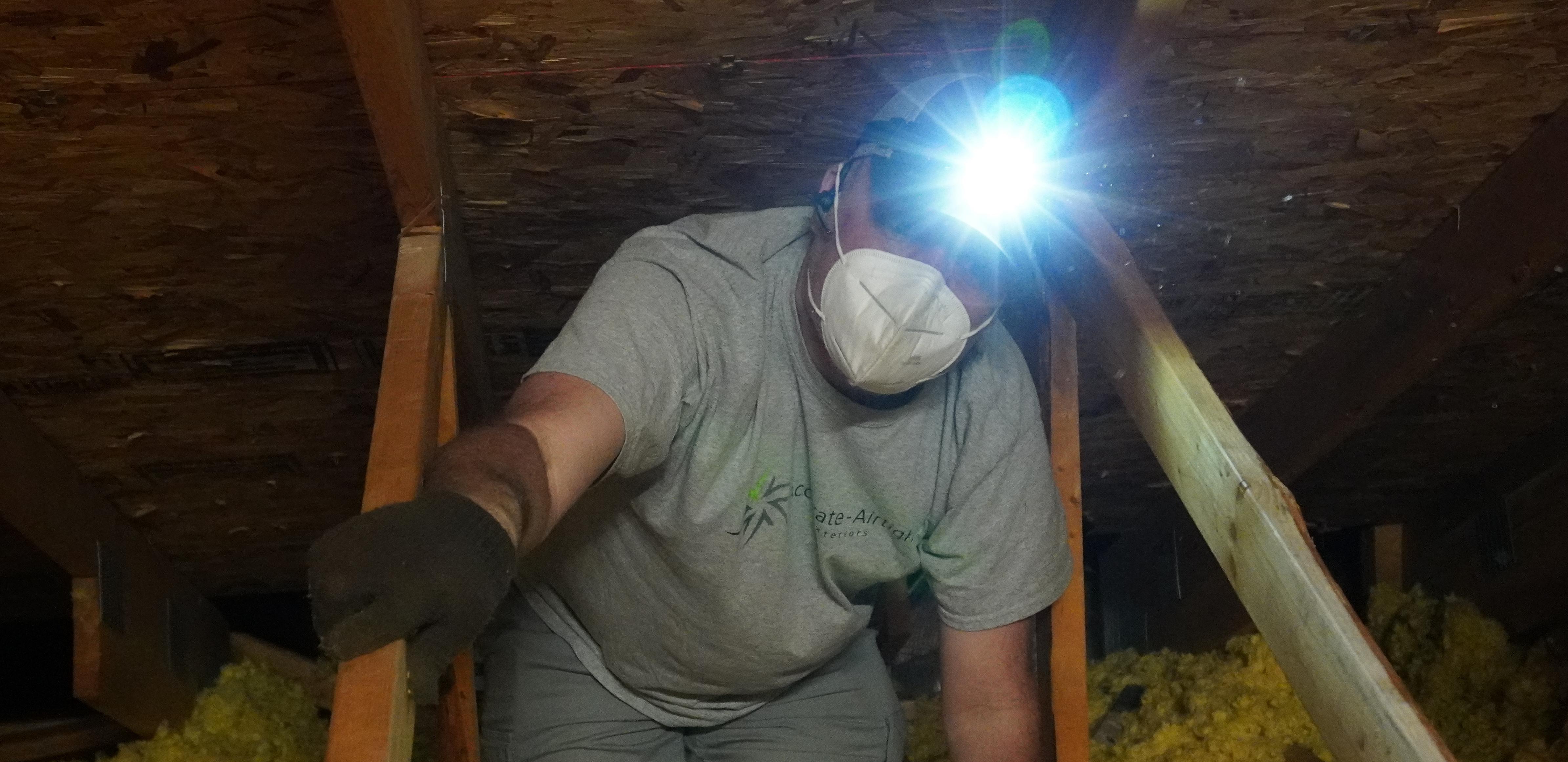 Accurate-Airtight Exteriors Crew Member Wearing A Head Lamp While Working In Attic Accurate-Airtight Exteriors Crew Member Wearing A Head Lamp While Working In Attic