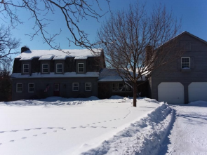 Front view of a snowy home during the winter Front view of a snowy home during the winter
