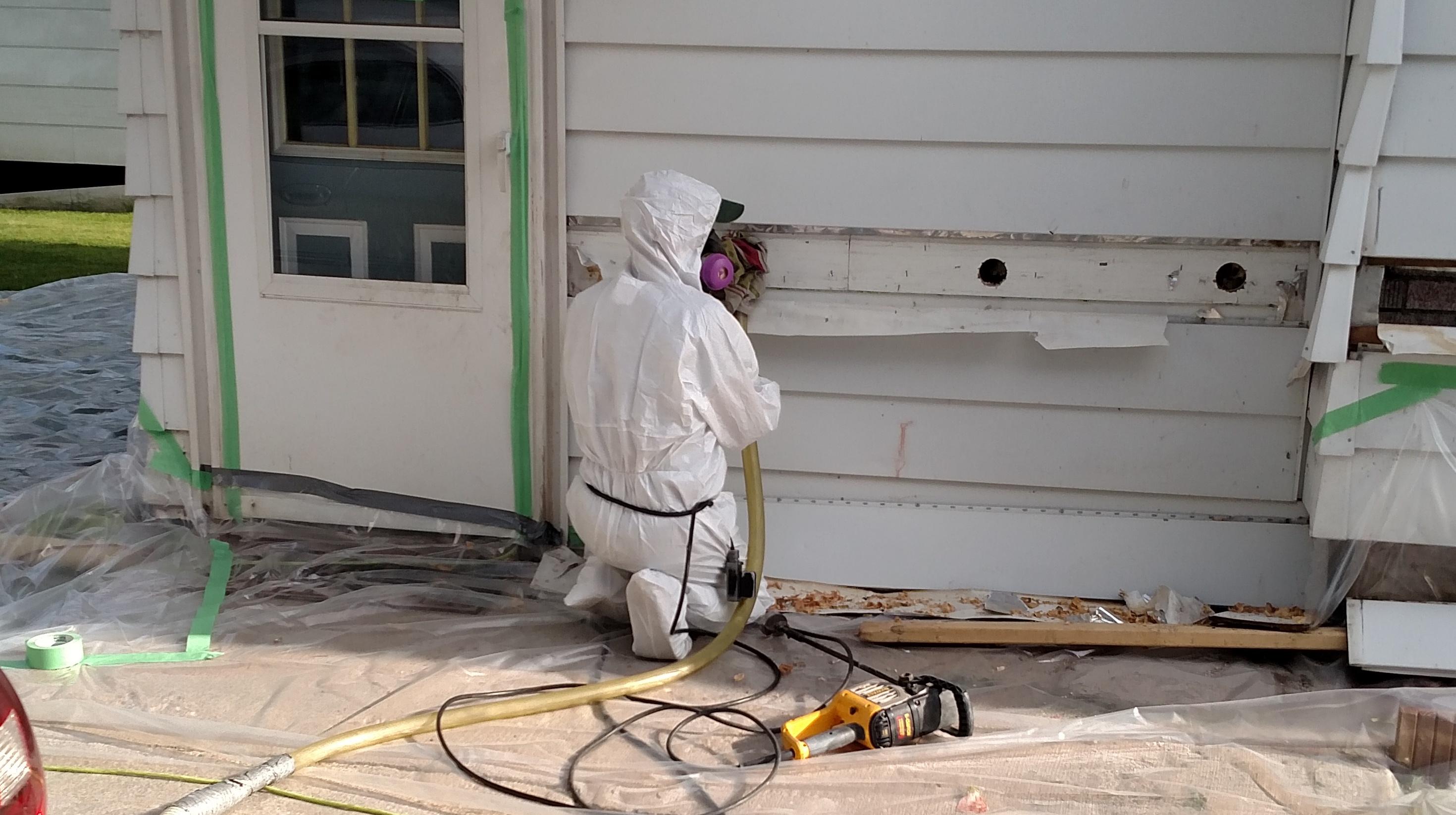 Blown Insulation Being Installed In Exterior Walls Of A House