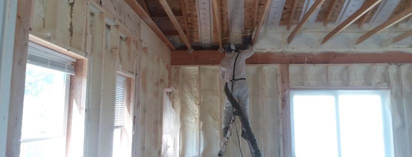 Worker Applying Spray Foam Insulation To New Construction Home