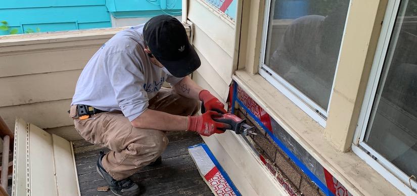 Accurate-Airtight Exteriors Performing Air Barrier Repair Worker Applying Caulk On Exterior Of A Home
