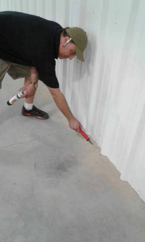 Using a smoke puffer to check for air leaks at the floor/wall junction.