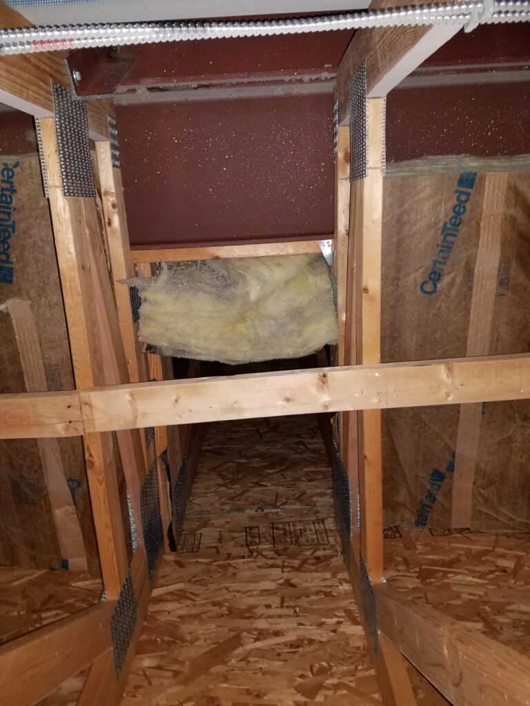 Example of misalignment of the air barrier and insulation in the attic of a multi-family building.