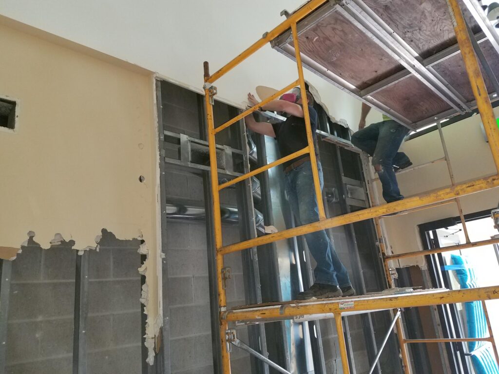 Scaffolding setup to access area of air leaks above ceiling.