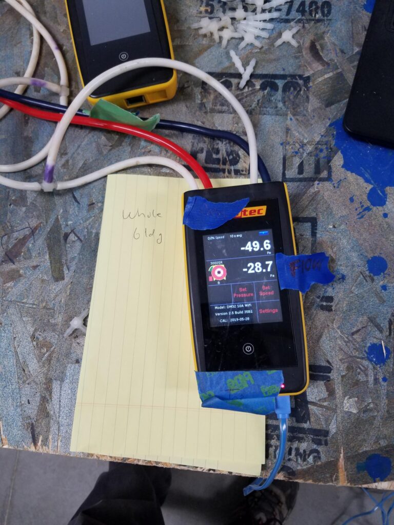 One or more digital pressure gauges are used to collect data during a blower door test.