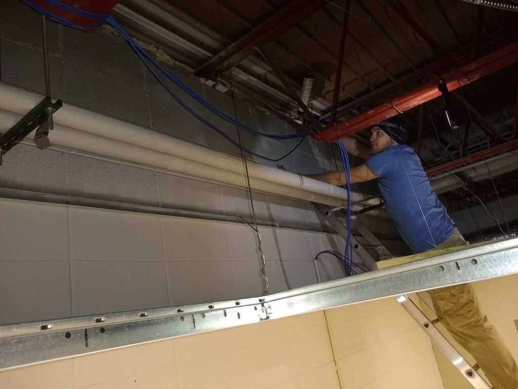 Examining air leaks concealed above the drop ceiling of a building.