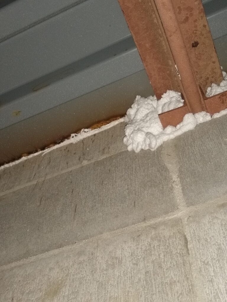 Air leaks at wall/roof junction sealed with one-part spray foam.