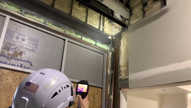 Using an infrared camera to inspect closed cell spray foam in walls of a commercial building.
