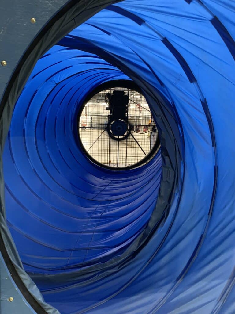 A snorkel is used to connect a G54 blower door fan to an exterior building opening.