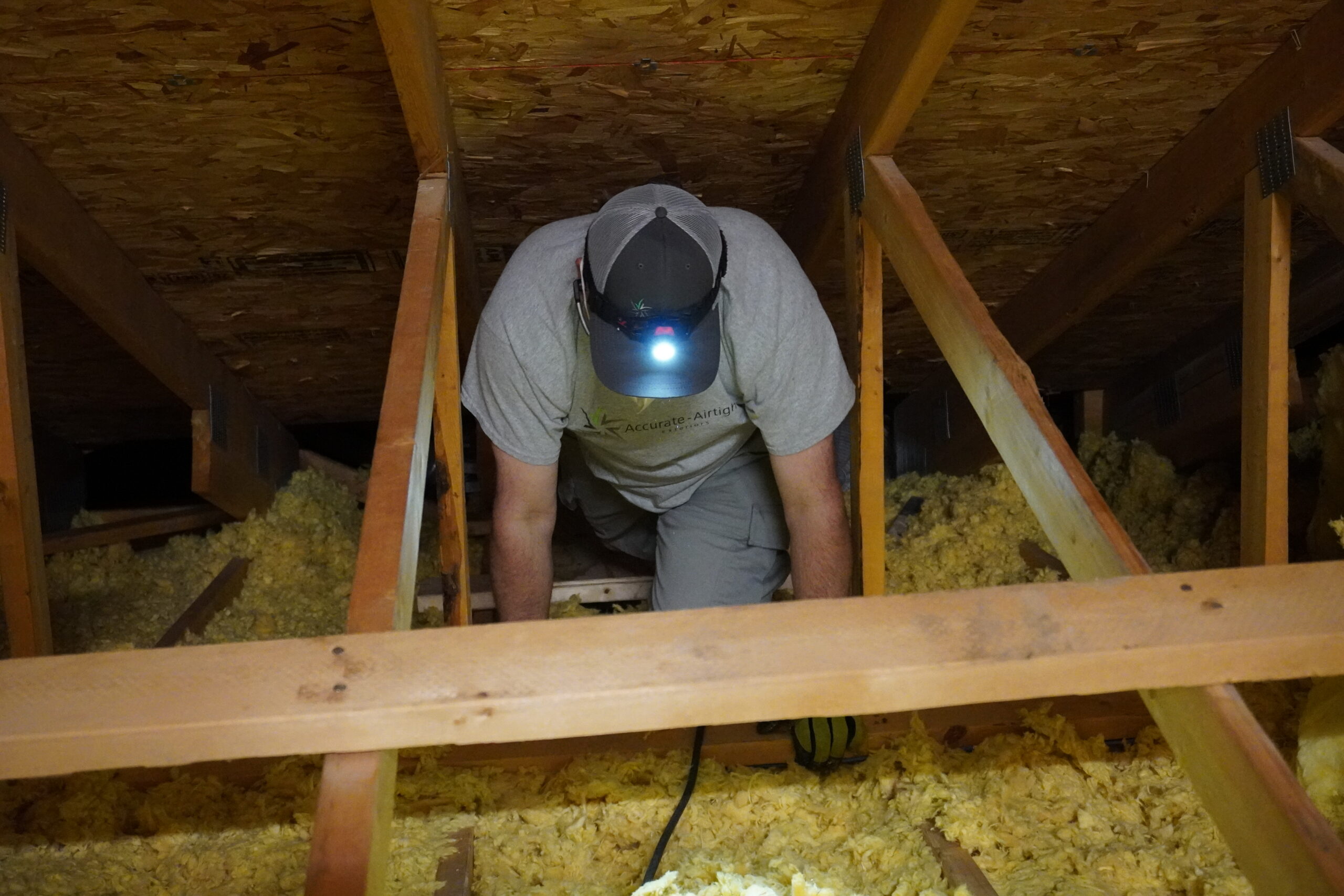 Inspecting an attic for air sealing opportunities.