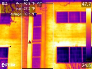 Infrared camera image showing temperature variations between windows and wall sections.