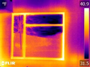 Infrared camera image of heat loss transmitted through a window frame.