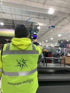 Using an infrared camera to check for ceiling air leaks in a manufacturing facility.